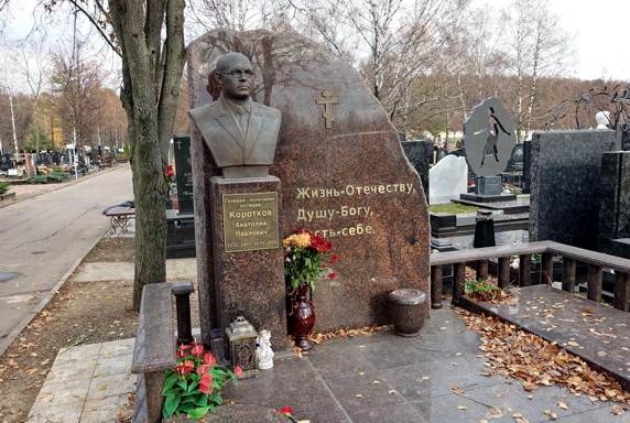Гранитный памятник со срезанным краем и бюст покойного на постаменте