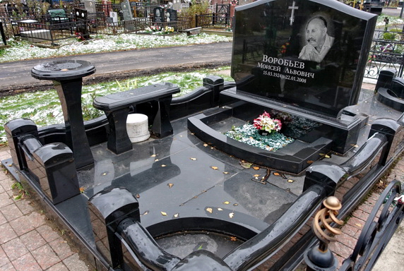Широкое место захоронения с широким памятником и лавочкой со столиком